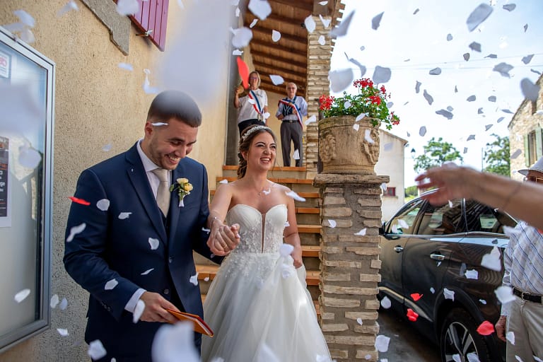 Photographe de mariage professionnel . Mariés qui sortent de la mairie, photographier par un photographe de mariage professionnel. Des papier en forme de cœur son lancer par les invités et la mariée est aux anges.