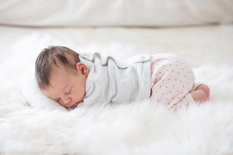 Photo de bébé sur un lit qui dort entouré d'un drap qui forme comme un nuage. Photographe bébé, photographe nouveau-né, photographe naissance